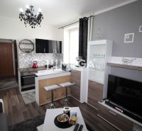 Konyha a nyaraló apartmanban kanapéval és fa dekorációjú padlóval.