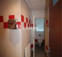 Irodai mellékhelyiség fehér és piros csempékkel.