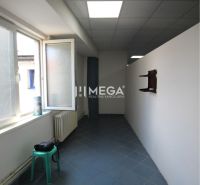 Keskeny szoba kék csempével és nagy ablakkal az üzlethelyiségben.