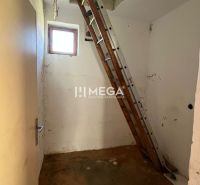 A létra egy családi ház padlására vezet, amelynek padlója fa mintázatú.