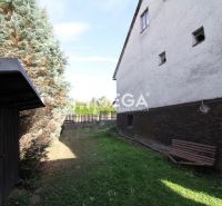 Kert egy családi ház mellett a Volica utcában, Volica városában, paddal és tűlevelű fákkal.