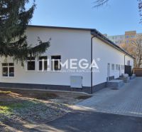 A Tyršova utcai üzlethelyiség épülete Humennéban fákkal körülvéve.