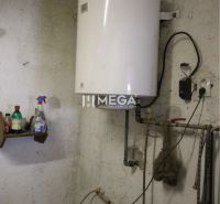 Bojler a családi ház technikai helyiségében, falra szerelt tartályokkal.