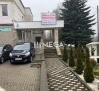 Épület az SNP utcában, Sninában, parkolóval és bérbeadó helyiségek reklámjával.