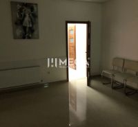 Az épület belső tere fehér székekkel, egy festménnyel és nyitott ajtóval, amelyen ellenőrző matrica van.