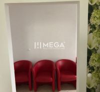 Három piros szék fehér falakkal és virágos tapétával egy épületben.