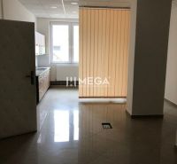 Belső tér csempével, konyhapulttal és függőleges redőnyökkel az épületben.