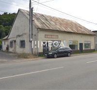 Üzlethelyiségek a Mieru utcában Stakčínban, az út mellett és egy parkoló autó.