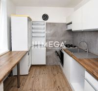 Konyha egy háromszobás lakásban, fa dekoros padlóval és elegáns konyhabútorral.