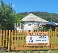 Családi ház eladó Kochanovce községben, zöld növényzettel körülvett kerítés mögött található.