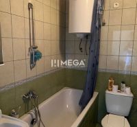 Fürdőszoba káddal és WC-vel, zöld csempével burkolva egy családi házban.