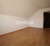 Kereskedelmi helyiségek fa mintázatú padlóval és ferde mennyezettel.