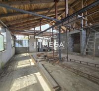 Egy építés alatt álló családi ház belső tere, látható fa tetőszerkezettel és vakolatlan falakkal.