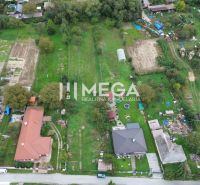 Lakóterületek Veľká Ida községben, Gomboš, zöldövezet és szomszédos házak által körülvéve.