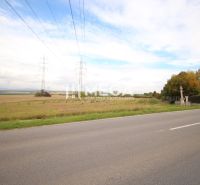 Kiterjedt lakóterületek az út mellett, Mokrance községben, elektromos vezetékekkel.
