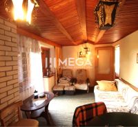 Nappali egy faházban téglafallal és fa dekorációval a mennyezeten.
