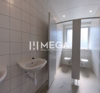 Mosdókagylóval és WC-vel ellátott szociális helyiség az irodákban, csempék a falakon.