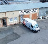 Épület a Humenné Fidlikova utcáján „Prestav Dom” felirattal és parkolóval.