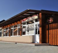 Vendéglátóhelyiségek a Budovateľská utcában, Vranov nad Topľou-ban, fa külső burkolattal.