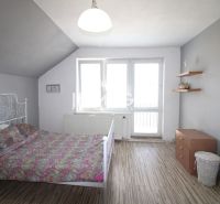 Családi ház belső tere ággyal, szekrénnyel és fa dekorációjú padlóval.