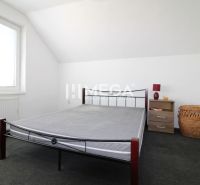 Hálószoba családi házban vasággyal, éjjeliszekrénnyel és kosárral.