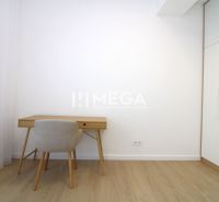 Dolgozósarok egy háromszobás lakásban, fa mintázatú padlóval és fehér bútorokkal.