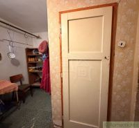 Családi ház belső tere előszobával, székkel és polcokkal. Konyhai eszközök lógnak itt.
