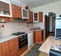 Konyha egy háromszobás lakásban fa dekor padlóval és konyhabútorral.
