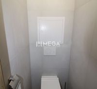 Két szobás lakás WC-je fa mintázatú padlóval és világos falakkal.
