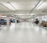 Földalatti garázsok kijelölt parkolóhelyekkel és leparkolt autókkal.