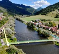 Švošov város panorámája zöld dombokkal és folyóval a lakóterületek számára.