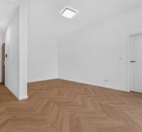 Háromszobás lakás fehér belső térrel, fa hatású padlóval és modern világítással.