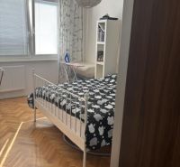 Hálószoba egy kétszobás lakásban, ággyal és fa dekorációjú padlóval.
