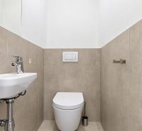 WC mosdókagylóval egy háromszobás lakásban, bézs csempe és fehér szaniter.