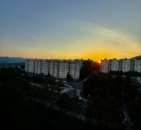 Naplemente a panelházak és a Karpatská úti út felett Besztercebányán.