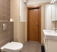 Fürdőszoba egy kétszobás lakásban csempével és fali WC-vel.