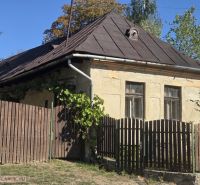 Régi családi ház Hejcén ferde tetővel és fa kerítéssel.