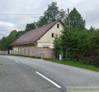 Családi ház Staskovban bádogtetővel, fákkal és kerítéssel körülvéve.
