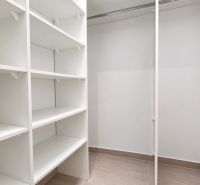 Tároló fehér polcokkal egy kétszobás lakásban.