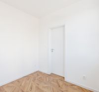 Szoba fehér falakkal és fa mintázatú padlóval, 2 szobás lakás.