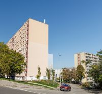 Lakóházak a pozsonyi Karlova Ves-i Adámiho utcában, zöldövezettel és úttal körülvéve.