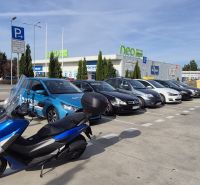 Parkoló autókkal és motorral a bevásárlóközpontnál, Malackán, a Javorová utcában.