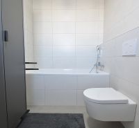 Fürdőszoba káddal és függesztett WC-vel egy háromszobás lakásban. Minimalista dizájn.