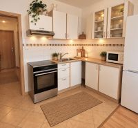 Konyha fehér szekrényekkel és készülékekkel egy kétszobás lakásban.