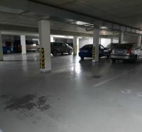 Podzemné garážové státie s parkovanými autami v 2-izbovom byte.