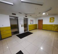 Kétliftű belső tér, sárga falakkal és világos csempékkel egy kétszobás lakásban.