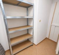 Tárolóhely egy kétszobás lakásban fém polccal és csempével.