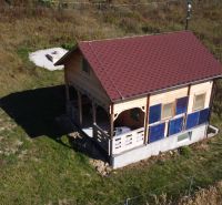Faház Horná Breznicában fa burkolattal és piros tetővel a zöld telken.