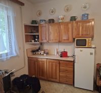 Konyha fa szekrényekkel, mikrohullámú sütővel és hűtőszekrénnyel, Ingatlan - lakhatás.