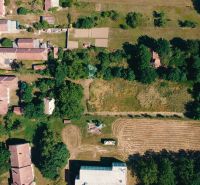 Légi felvétel a Csermányban található lakóterületekről, amelyeket zöldterület és közúti infrastruktúra vesz körül.